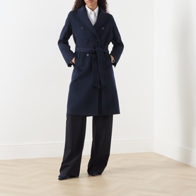 Model wearing Marella Laghi Belted Coat in navy, double-breasted with self-tie belt, styled with white shirt and wide-leg trousers.
