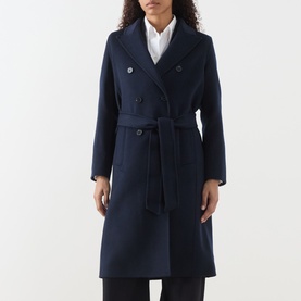 Model wearing Marella Laghi Belted Coat in navy, double-breasted with peak lapel, self-tie waist belt, styled with white shirt underneath.
