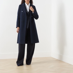 Model wearing Marella Laghi Belted Coat in navy, double-breasted with peak lapels, styled with black wide-leg trousers and white shirt.