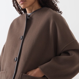 Model wearing Marella brown wool coat with collarless neckline, dark trim detail, front button fastening and patch pockets.