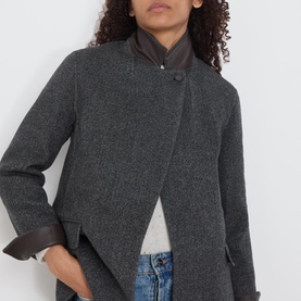 Model wearing Marella melange dark wool coat with asymmetric front, leather-trim cuffs and collar detail, styled with blue jeans