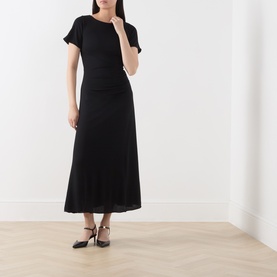 Model wearing Marella black short-sleeve midi dress in viscose blend, with ruched waist detail, paired with black heeled mules.