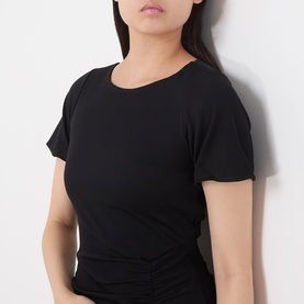 Model wearing Marella black viscose dress, close-up showing fitted short-sleeve bodice with round neckline and ruched waist detail.