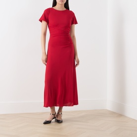 Model wearing Marella red midi dress with flutter sleeves, ruched waist detail, and flared skirt, styled with black strappy heels.