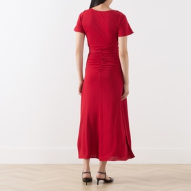 Model wearing Marella red midi dress, back view, ruched centre-back detail, short sleeves, flared hem, styled with black heeled mules