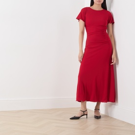 Model wearing Marella red midi dress with short sleeves, ruched waist detail and flared skirt, styled with black heels.