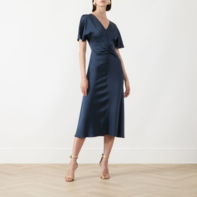Model wearing Marella Aviation blue satin midi dress with flutter sleeves, wrap bodice and flared skirt, styled with gold strappy heels