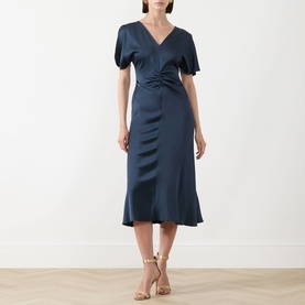 Model wearing Marella aviation blue satin midi dress with V-neck, puff sleeves and ruched front detail, styled with nude heeled sandals.