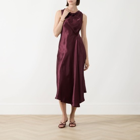 Model wearing Marella Libero Draped Dress in Bordeaux; sleeveless satin midi with draped neckline and asymmetric hem, styled with strappy sandals