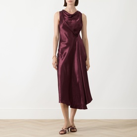Model wearing Marella Libero Draped Dress in bordeaux satin, sleeveless with cowl neck, asymmetric midi hem, styled with tan strappy sandals