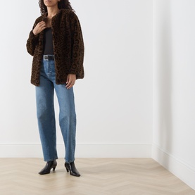 Model wearing Marella cocoa spotted faux fur jacket, styled with blue straight-leg jeans and black heeled ankle boots.
