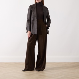 Model wearing Marella brown 100% leather jacket styled with dark roll-neck and wide-leg trousers.