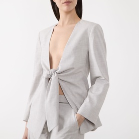 Model wearing Marella Facella Tie-Front Blazer in light grey with deep V-neckline, tie-front detail and wide sleeves, styled with matching trousers.