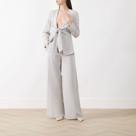 Model wearing Marella Facella Tie-Front Blazer in light grey with tie-front fastening, styled with matching wide-leg trousers and white heels.