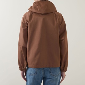 Model wearing Marella Calamo Water-Repellent Jacket in Tobacco Brown, back view, with detachable hood and raglan sleeves, styled with blue jeans.