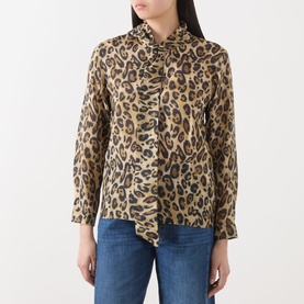 Model wearing Marella Nastro Silk Leopard Print Blouse in beige spotted, featuring pussy bow tie and long sleeves, styled with blue jeans.