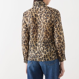 Model wearing Marella Nastro Silk Leopard Print Blouse in beige spotted, showing back view with stand collar and long sleeves, styled with blue jeans.