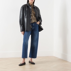 Model wearing Marella Nastro Silk Leopard Print Blouse in Beige Spotted, styled with black leather jacket, blue cropped jeans and black loafers.