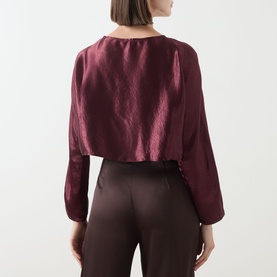 Model wearing Marella bordeaux satin acetate shirt, back view, with long sleeves and relaxed fit, styled with dark brown trousers.