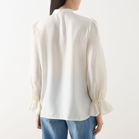 Model wearing Marella Caldaia Silk Ruffle Blouse in white, showing back view with puff shoulders and elasticated flared cuffs, styled with blue jeans