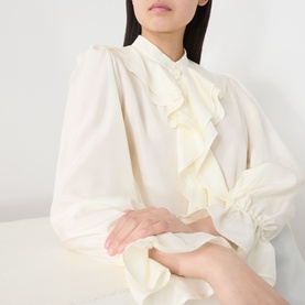 Model wearing Marella Caldaia Silk Ruffle Blouse in white with stand collar, front ruffle detail, puff shoulders and elasticated flared cuffs