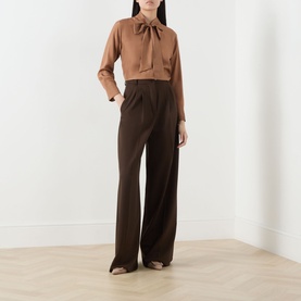 Model wearing Marella Kabala Silk Tie Front Blouse in Tobacco Brown with stand collar and tie front, styled with dark brown wide-leg trousers.