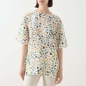 Model wearing Marella White Pebbles silk shirt with abstract pebble print, short flutter sleeves and relaxed fit.