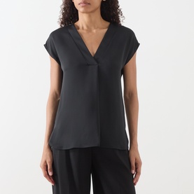 Model wearing Marella Brina Front-Pleat Blouse in black, featuring V-neckline, cap sleeves and front pleat, styled with black wide-leg trousers.