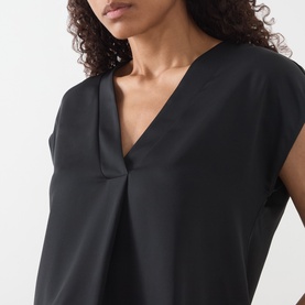 Model wearing Marella Brina Front-Pleat Blouse in black, showing V-neckline, cap sleeves and front pleat detail in smooth fabric.