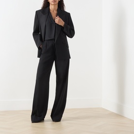 Model wearing Marella Brina Front-Pleat Blouse in black, styled with matching black blazer and wide-leg trousers.