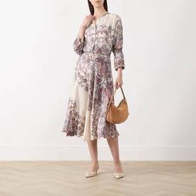 Model wearing Marella Decano Printed Skirt in cream satin, flared midi length with floral print, styled with matching top, tan bag and nude heels.