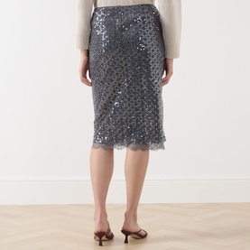 Model wearing Marella medium grey sequin midi skirt with scalloped lace hem, shown from behind, styled with tan heeled mules.