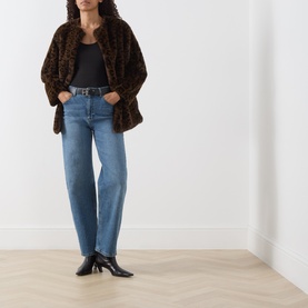 Model wearing Marella black fitted T-shirt, styled with brown faux fur coat, blue straight-leg jeans and black heeled ankle boots.