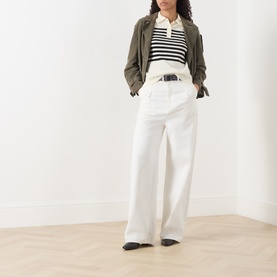 Model wearing Marella cream wool-cashmere top styled with wide-leg white trousers, black belt, striped polo, and khaki jacket.