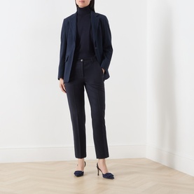 Model wearing Marella navy lyocell top styled with matching navy blazer and tailored trousers, paired with navy heels.