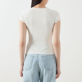 Model wearing Marella Vicario Rib-Knitted Sweater in white, rear view, with light blue wide-leg jeans.