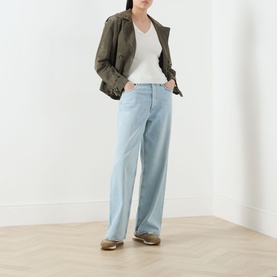 Model wearing Marella Vicario Rib-Knitted Sweater in white, V-neckline, short sleeves, styled with light blue wide-leg jeans and khaki jacket.