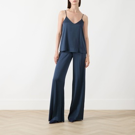 Model wearing Marella aviation blue satin camisole top with thin straps, styled with matching wide-leg trousers.