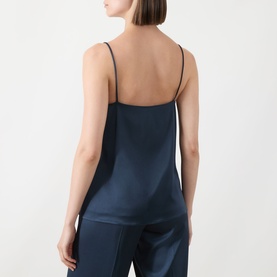Model wearing Marella aviation blue satin camisole top with thin straps, shown from back, paired with navy trousers