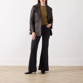 Model wearing Marella black flared cotton trousers, styled with a dark leather jacket, olive top and black kitten heel shoes.