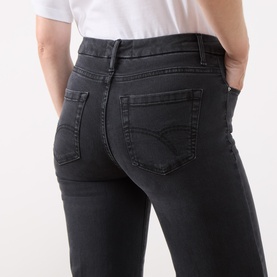 Model wearing Marella black slim-fit jeans, rear view showing back pockets and belt loops, styled with a white top.