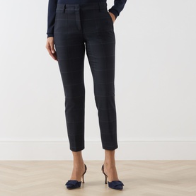 Model wearing Marella Navy Check trousers, styled with navy kitten heel mules and a navy long-sleeve top.