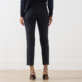 Model wearing Marella navy check trousers, rear view, styled with a navy top and black block-heel sandals.