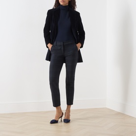 Model wearing Marella Navy Check trousers, styled with a navy roll-neck and black coat, paired with navy slingback heels.