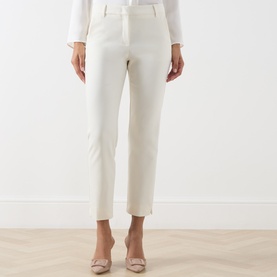 Model wearing Marella white slim-leg trousers in cotton blend, styled with blush heels and a white top.