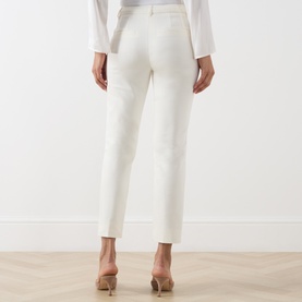 Model wearing Marella white tailored trousers, rear view, styled with a white shirt and nude heels.