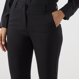 Model wearing Marella black tailored trousers with slim fit, side pockets and belt loops, styled with a black blouse.