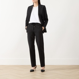 Model wearing Marella black tailored trousers with drawstring waist, styled with black blazer, white tee and black heels.