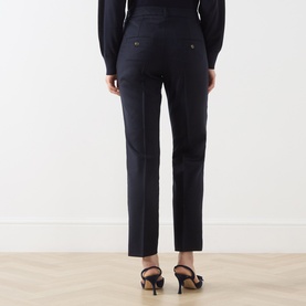 Model wearing Marella Macina Straight Leg Trousers in navy, showing rear view with buttoned jet pockets and pressed creases, styled with black heels.