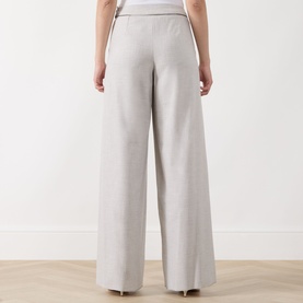 Model wearing Marella Pausa Wide-Leg Trousers in light grey, shown from behind, with wide-leg silhouette and satin-trim waistband detail.